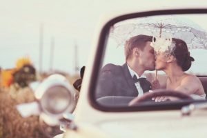 sposi in macchina che si baciano